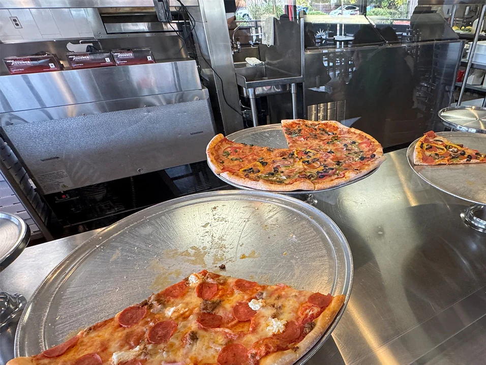 Pizzas on serving platforms at a restaurant