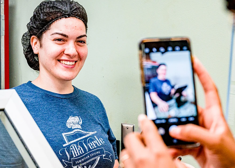 Someone taking a photo of a worker wearing a hair net