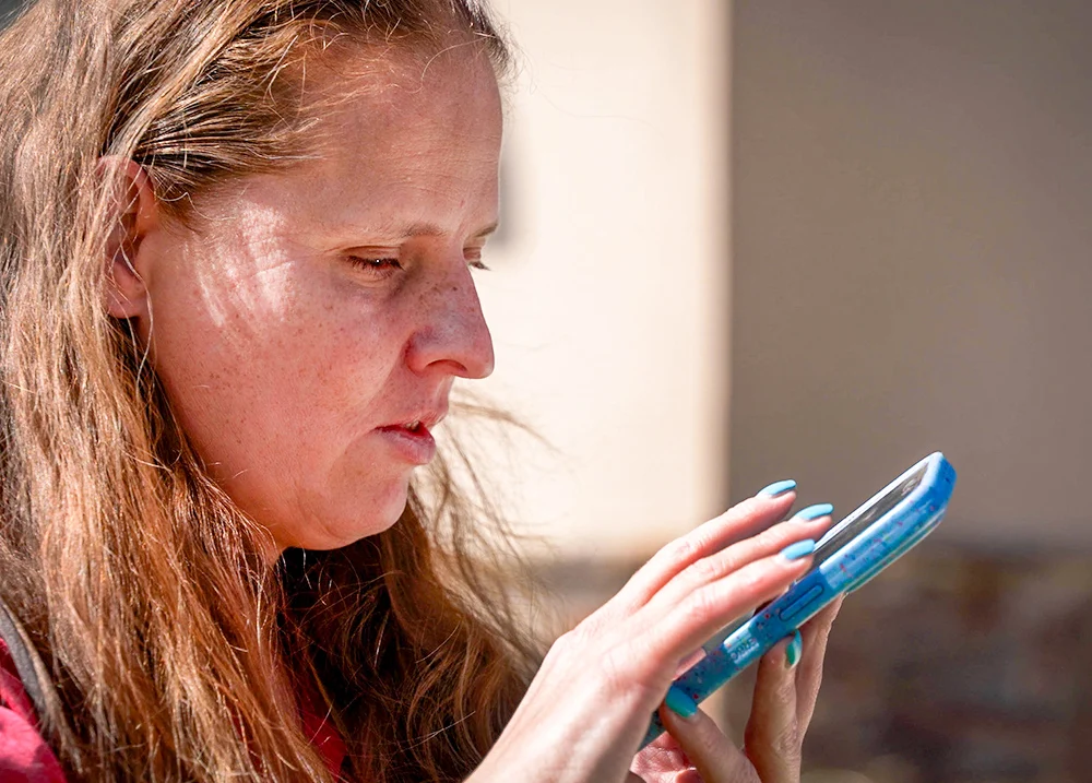 Woman with a visual impairment using a cell phone