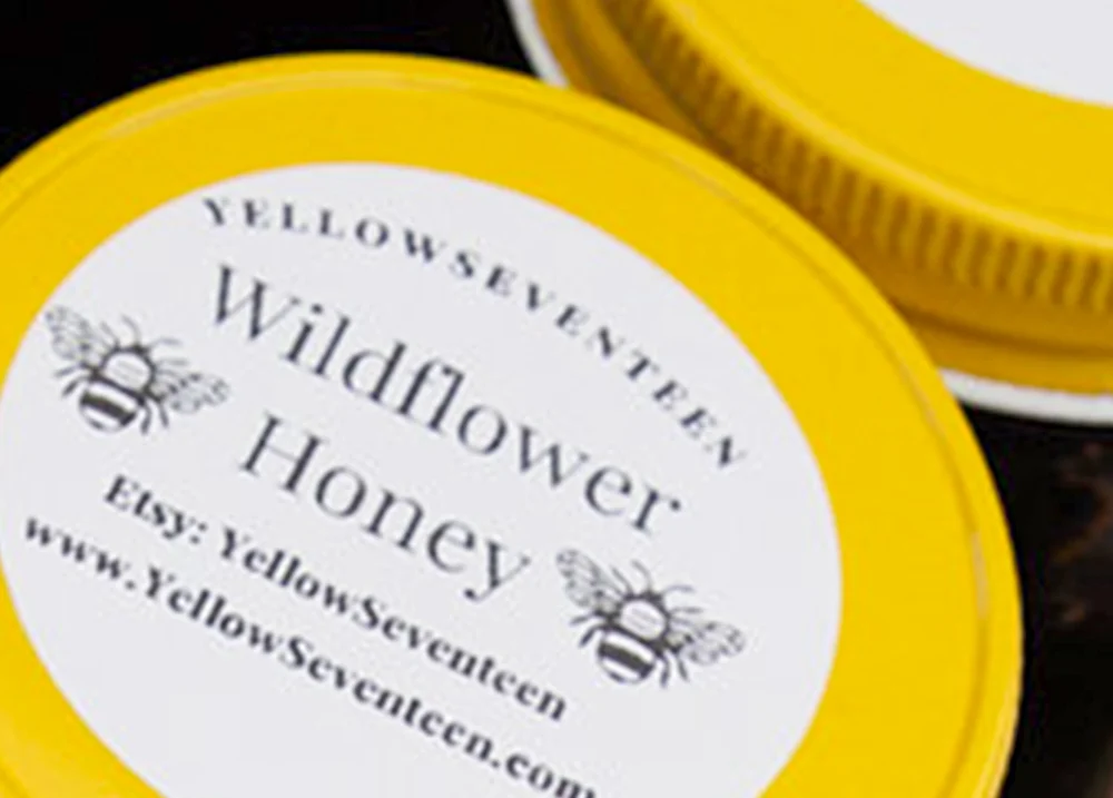 The top of a honey container that says Wildflower Honey with an Etsy site and website on the label