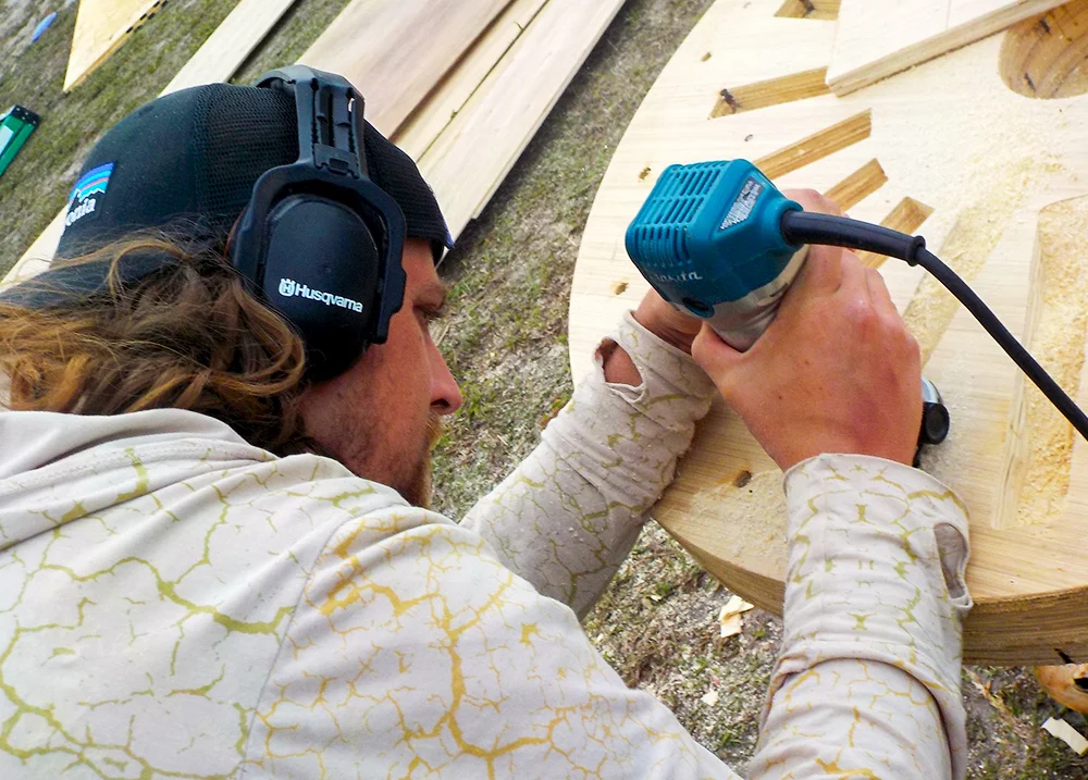 Man using a tool to make designs in a piece of wood