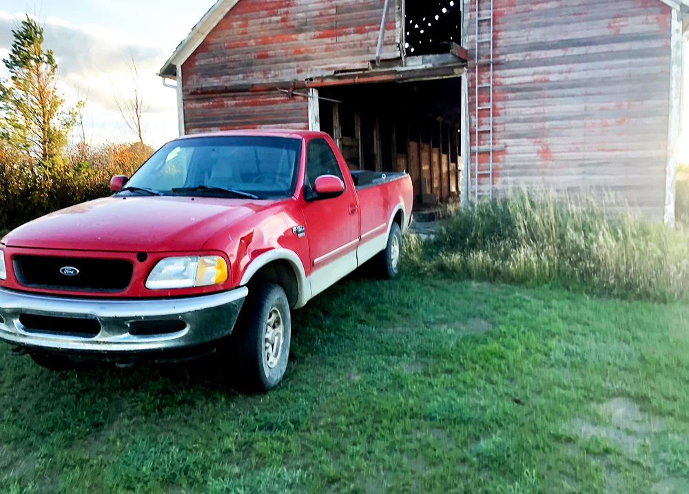 A truck backed up to a barn