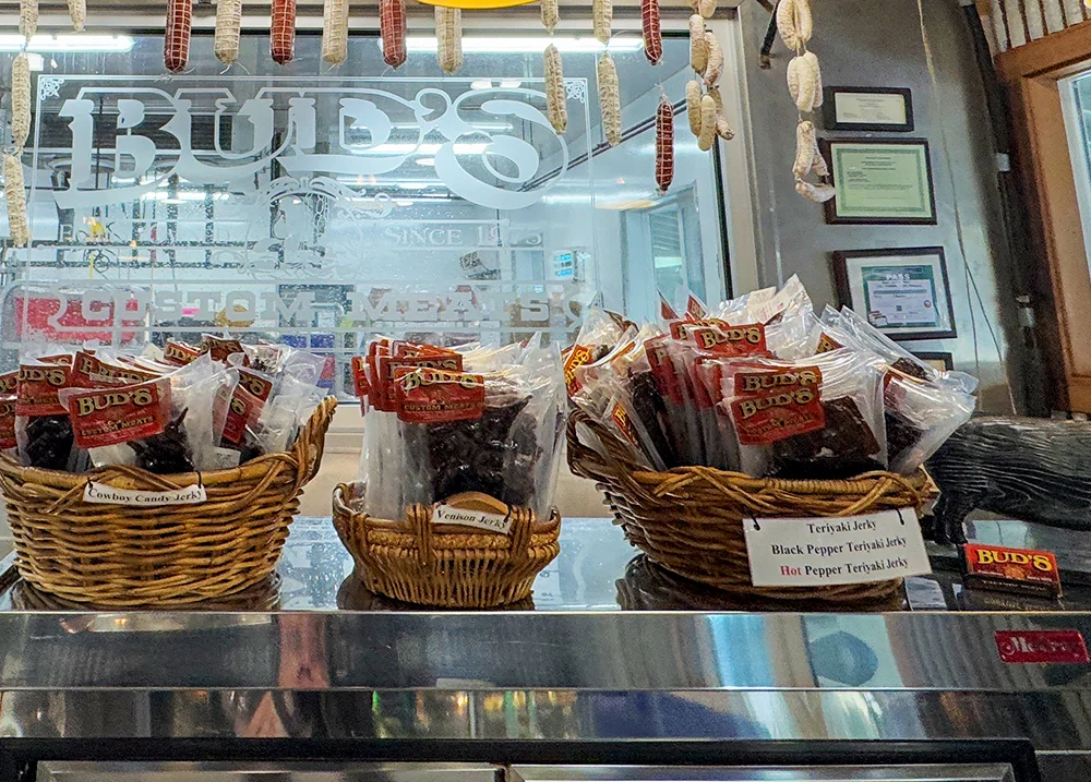 A meat shop with framed licenses on the wall behind the counter