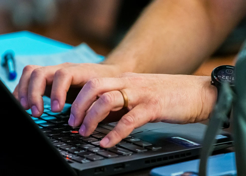 Hands typing on a laptop keyboard