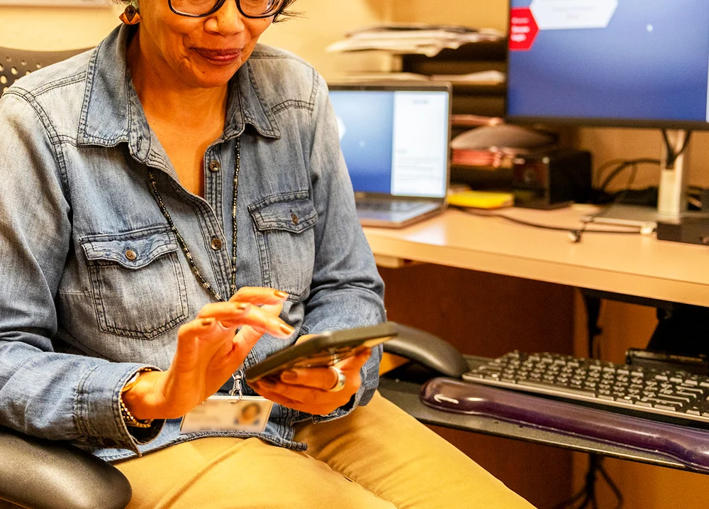 Woman sitting at a desk using her cell phone