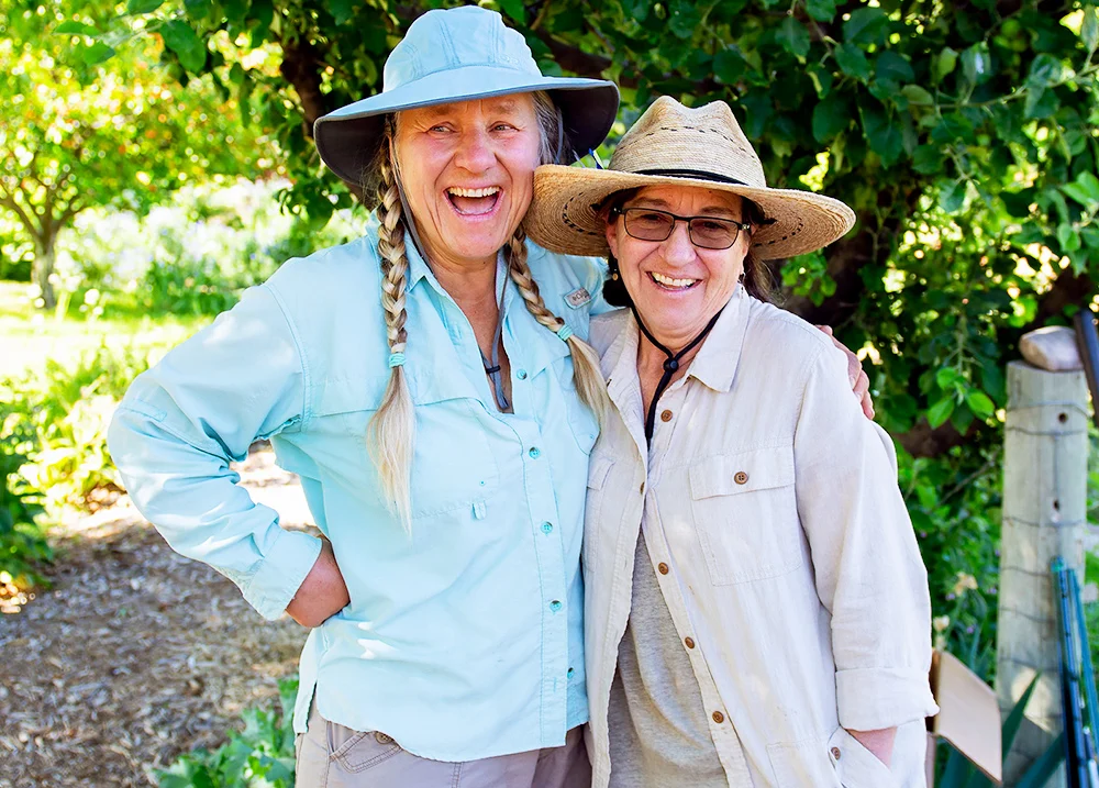 Two women side hug and smile