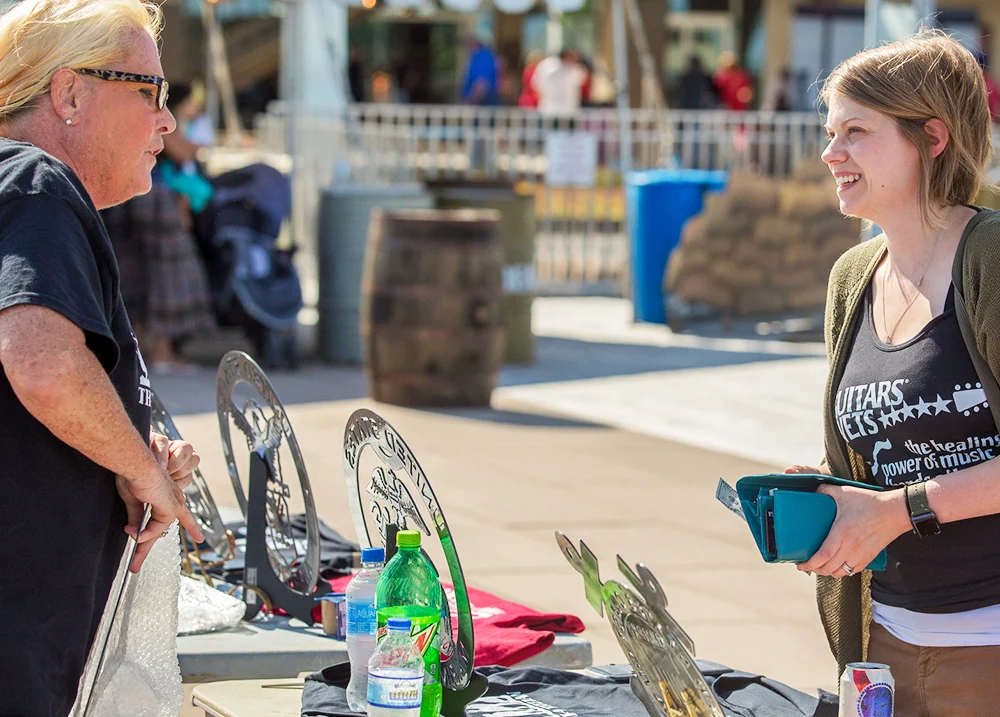 Customer purchasing a sign from a vendor at an outdoor event