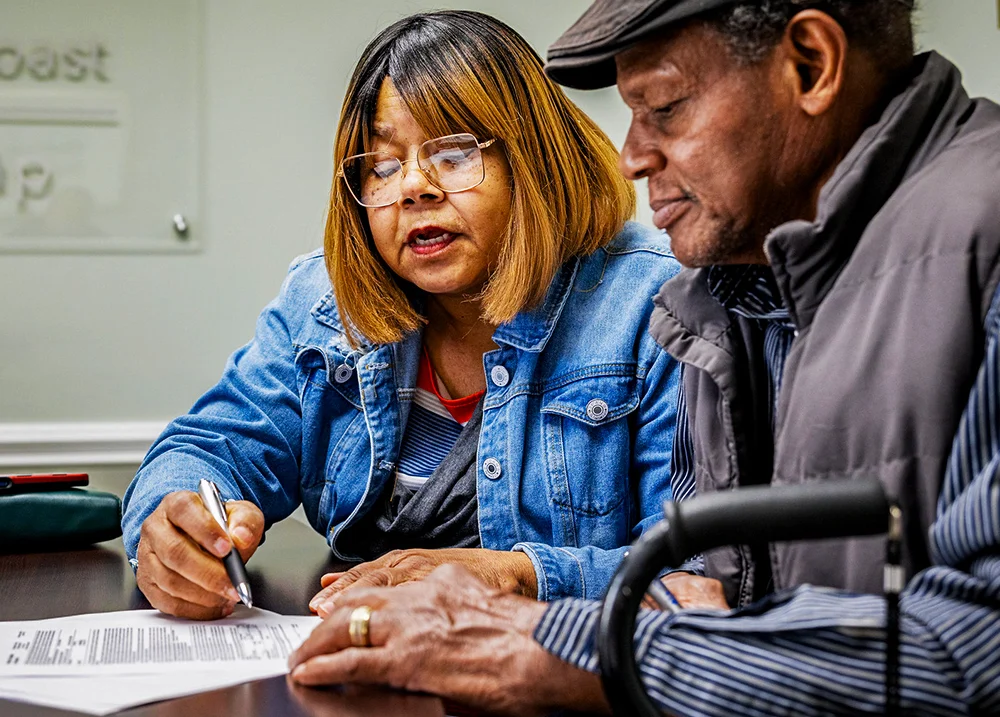 Two people sitting together looking at a piece of paper