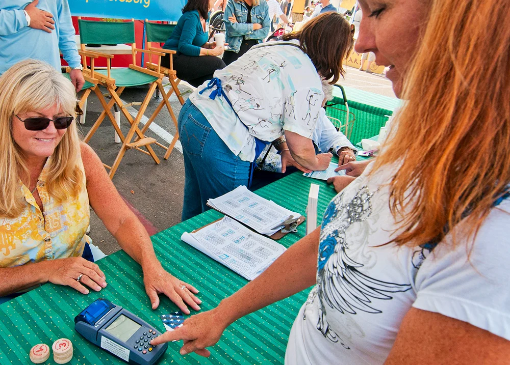 Woman punching numbers on a payment machine at an outdoor market
