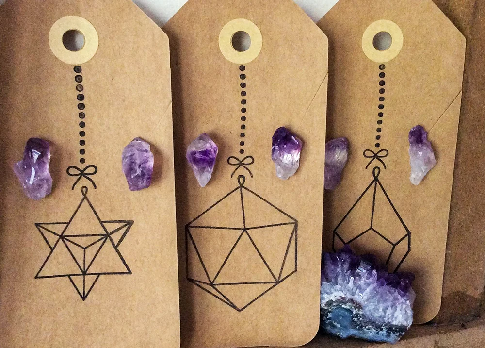 Three pairs of purple crystal earrings in nicely designed earring display cards