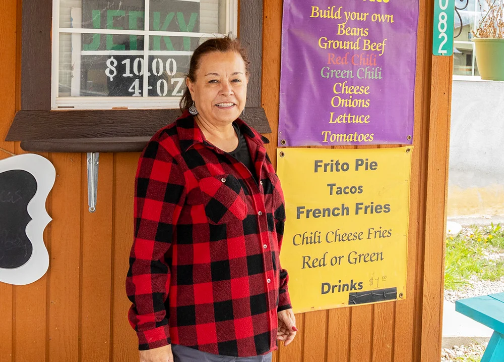 Woman standing in front of a business that sells tacos
