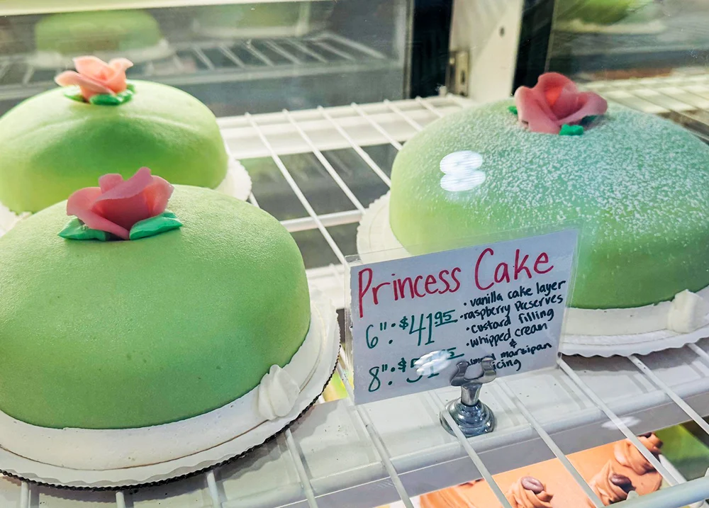 Green princess cakes for sale in a display case