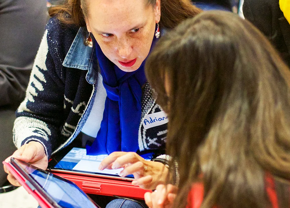 Two people look at a digital tablet screen